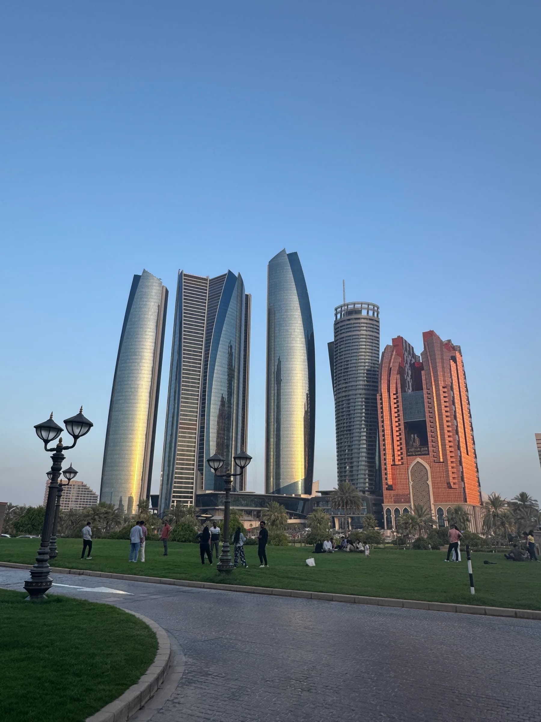 Abu Dhabi towers seen beyond a green city park.
