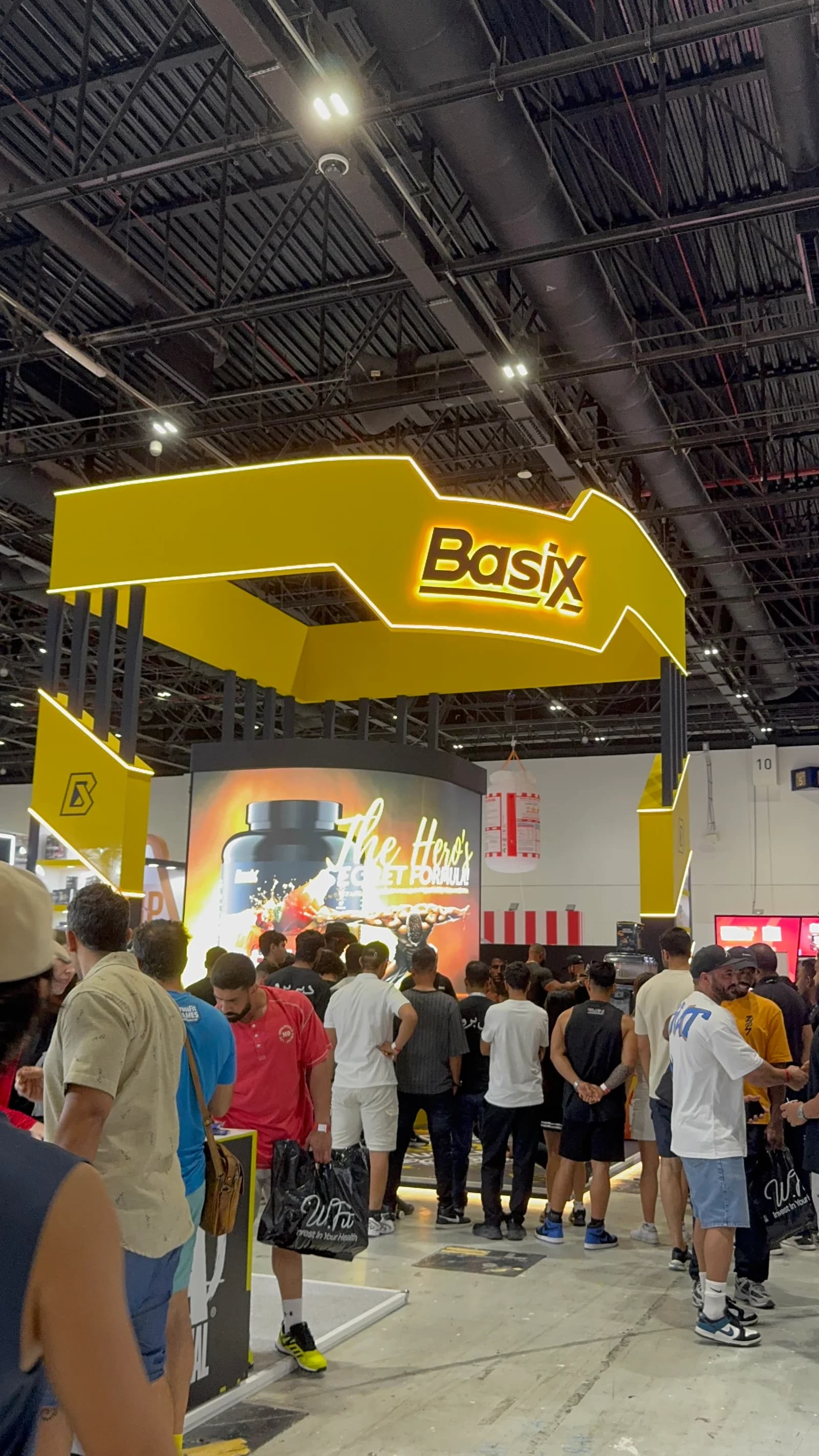 Visitors around a bright yellow Basix merchandise booth at Dubai Pro in 2025