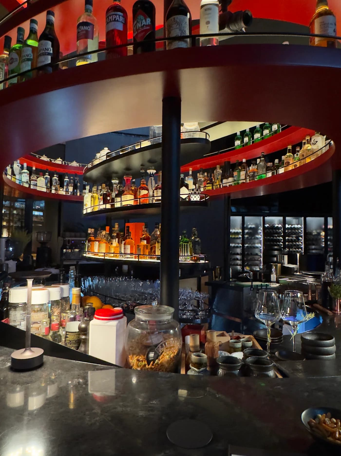 Curved shelves of bottles above the bar at Kasumigaseki restaurant