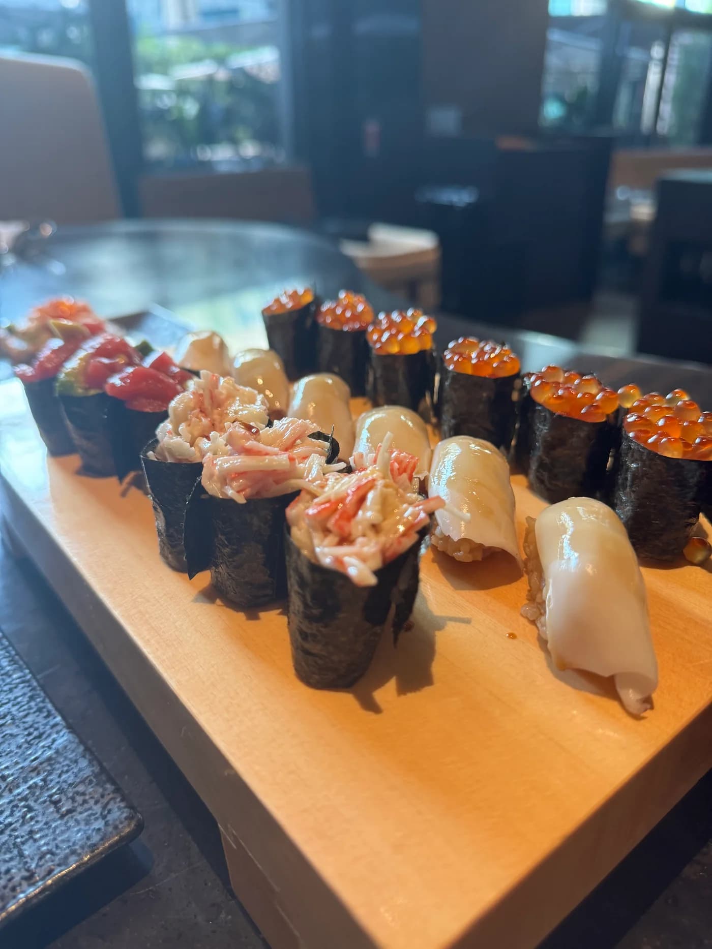 A wooden board of gunkan and nigiri sushi at Kasumigaseki Dubai