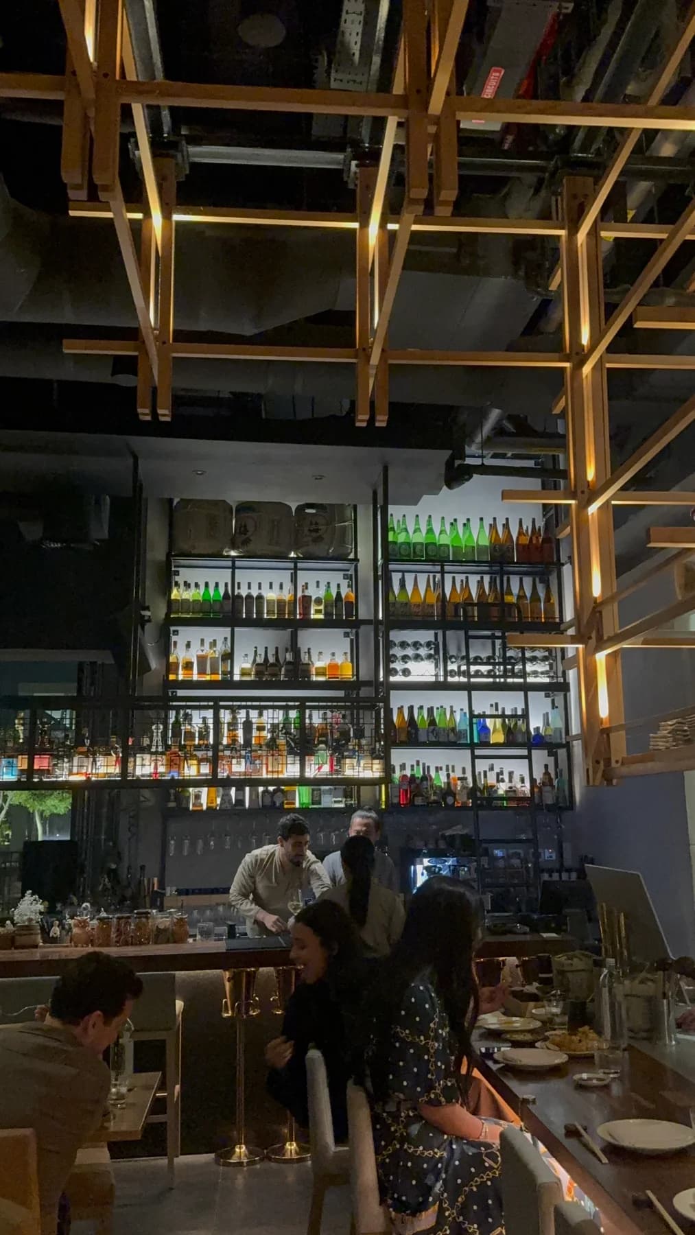 Wooden ceiling details and illuminated bottle shelves inside NIRI