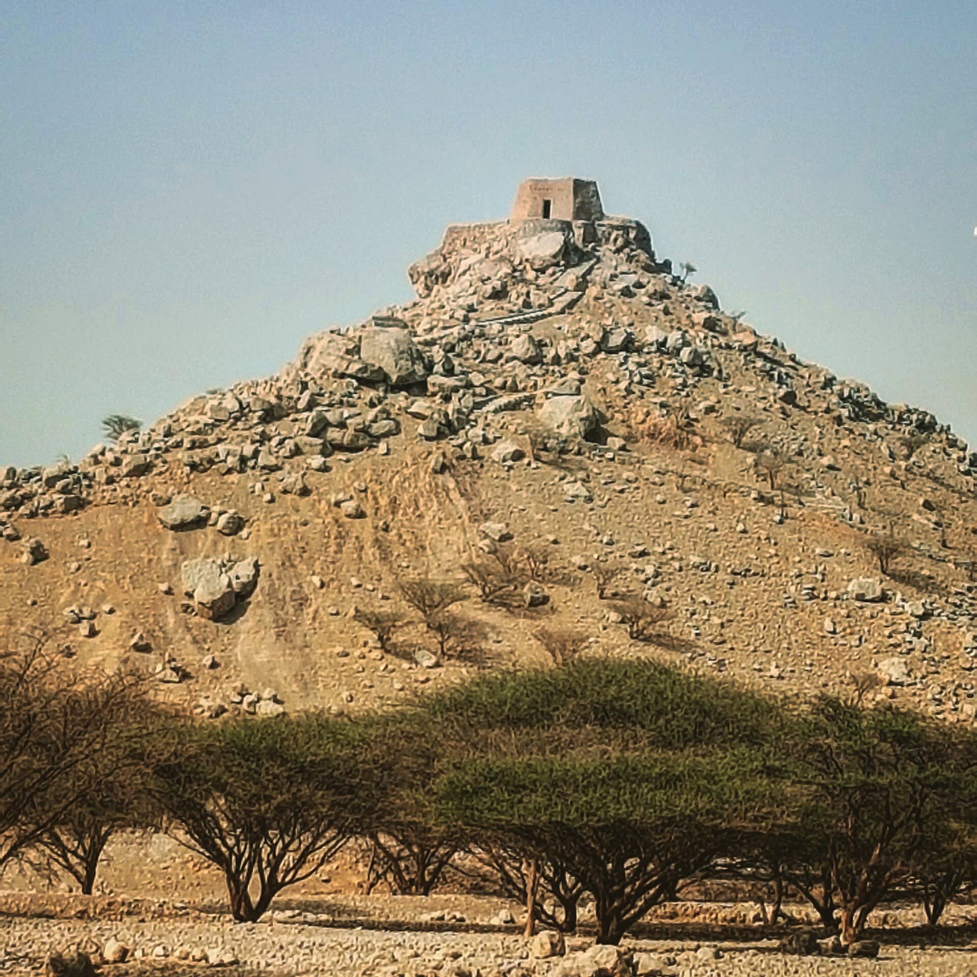 Dhayah's hilltop setting. The climb is part of the visit, not a drive-up viewpoint.
